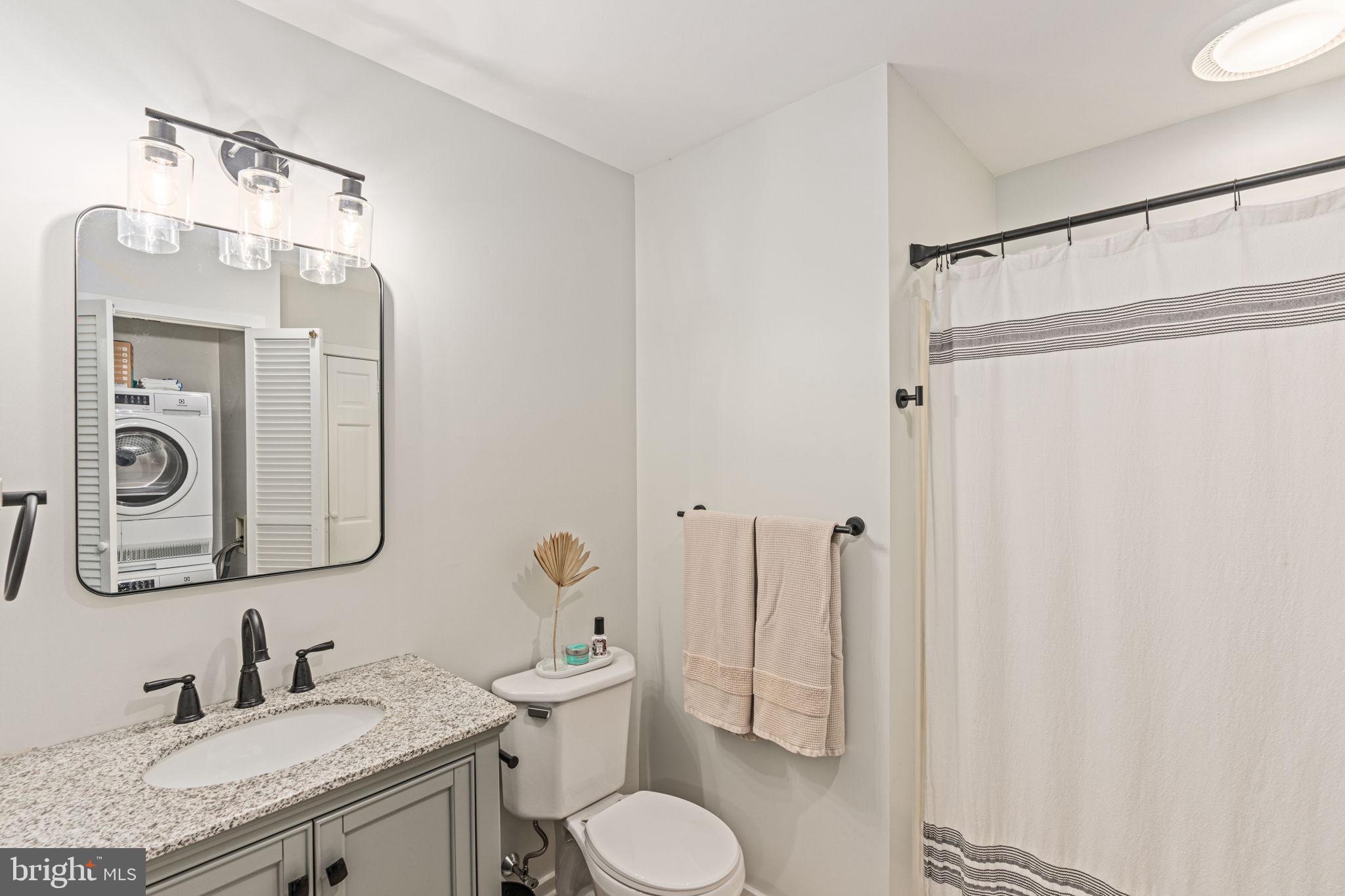 137 Callowhill Road Chalfont, PA 18914 - Photo 50 of 59 a bathroom with a granite countertop sink toilet a mirror and shower curtain