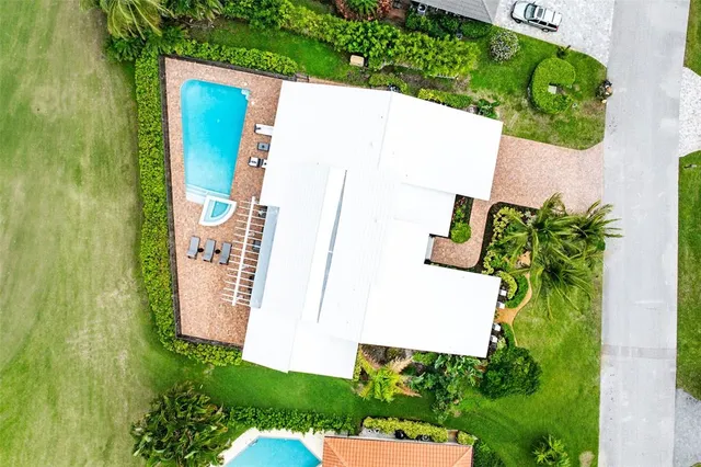 an aerial view of residential houses with outdoor space and swimming pool