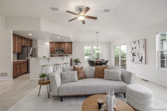 a living room with furniture a fireplace and a chandelier