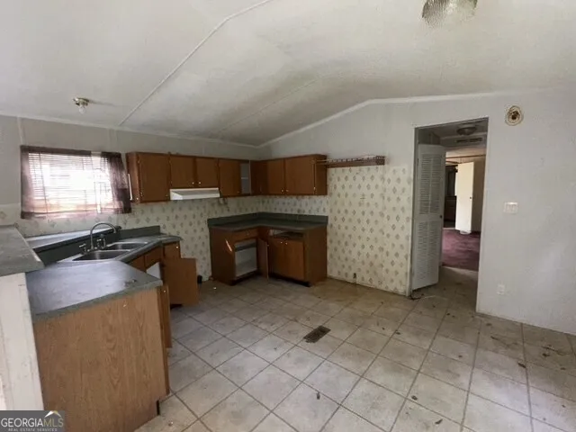 a kitchen with granite countertop a sink cabinets and stainless steel appliances