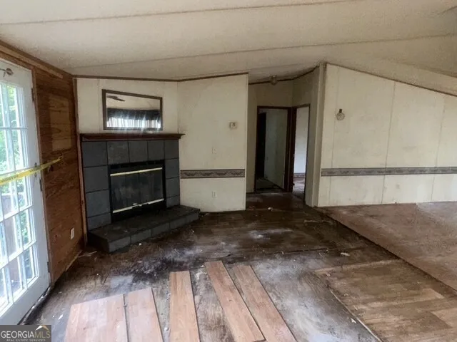 a view of an empty room with a fireplace and a window