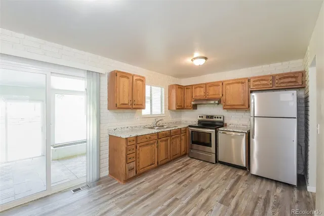 a kitchen with a refrigerator sink and cabinets
