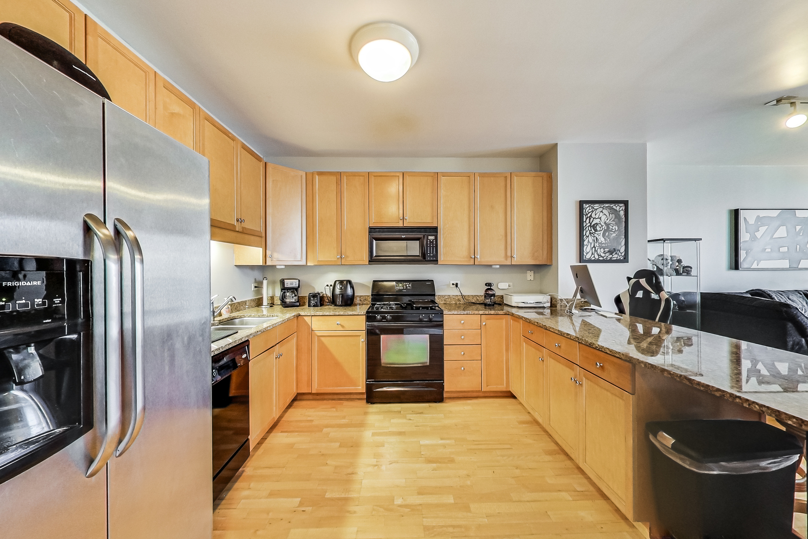 1101 South State Street, Unit 2001 Chicago, IL 60605 - Photo 13 of 24 a kitchen with stainless steel appliances granite countertop a sink a stove and a refrigerator
