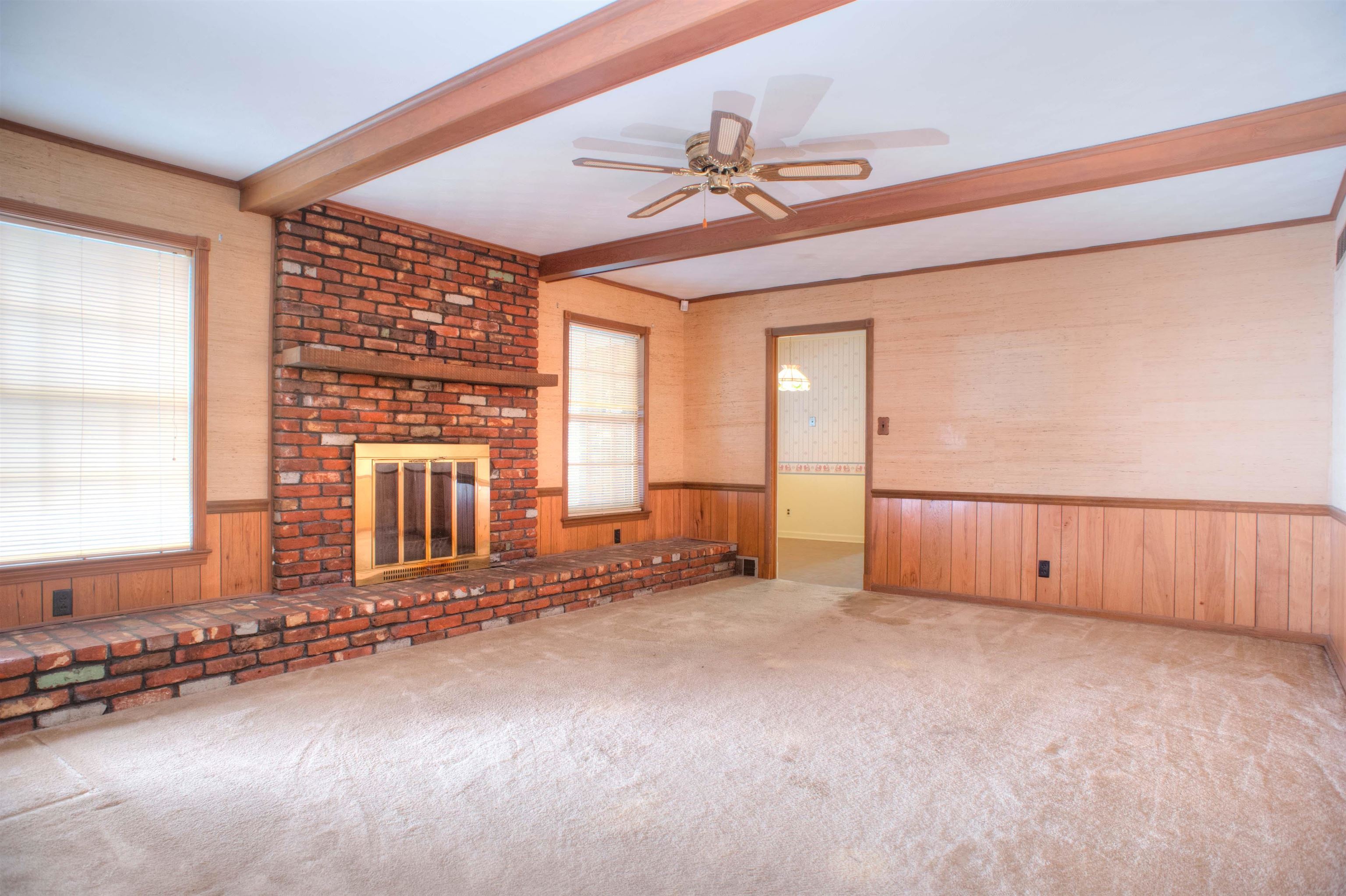 Den/Family Room features Fireplace with Raised Brick Hearth, Wood Beamed Ceiling with Ceiling Fan