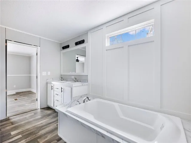 a bathroom with a tub sink and mirror