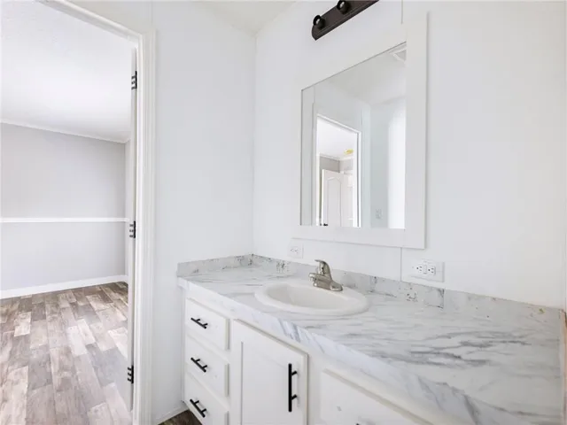 a bathroom with a granite countertop sink and a mirror