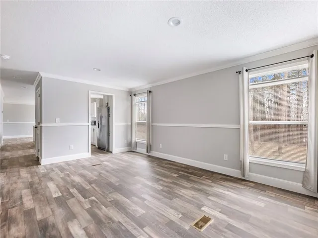 a view of empty room with wooden floor and fireplace