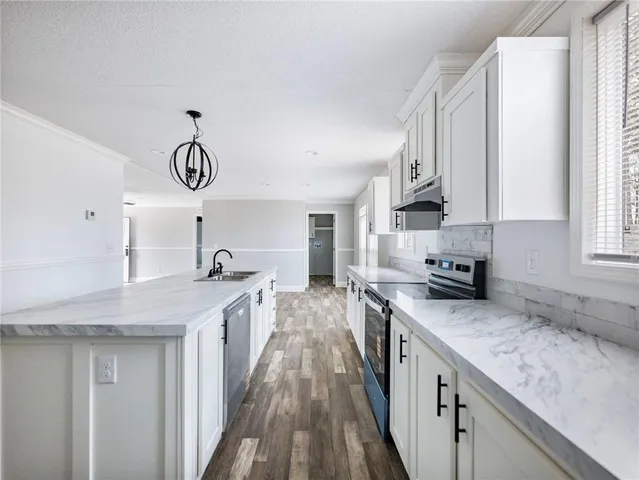a kitchen with stainless steel appliances granite countertop a sink stove and cabinets