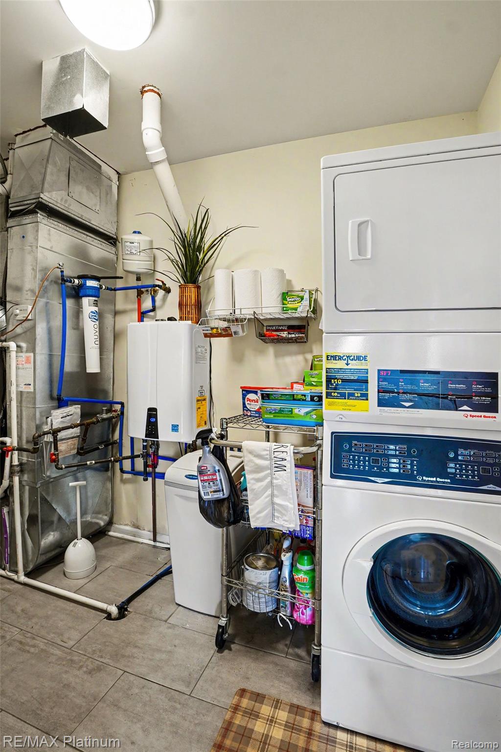 10217 Crossview Trail Howell, MI 48855 - Photo 23 of 26 Dedicated utility space featuring stacked laundry appliances and light tile flooring