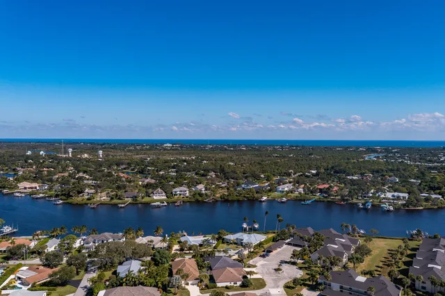 an aerial view of ocean and residential houses with outdoor space
