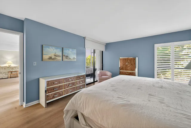 a bedroom with a bed and a dresser next to a window