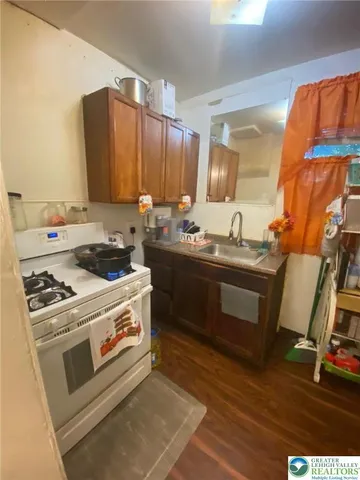 a kitchen with a stove a sink and a wooden cabinets