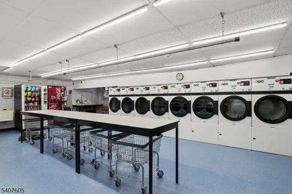 a utility room with stainless steel appliances a white stove top oven a sink and dishwasher