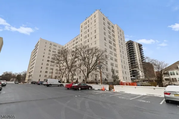 a view of a buildings with cars parked in front of it