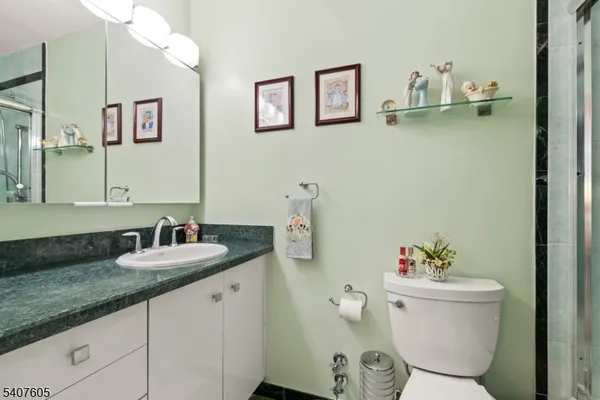 a bathroom with a granite countertop sink a toilet and a mirror