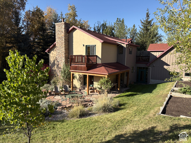 725 Canyon Road Smithfield, UT 84335 - Photo 75 of 100 Stucco exterior with a stone chimney, multiple balconies, and a covered patio