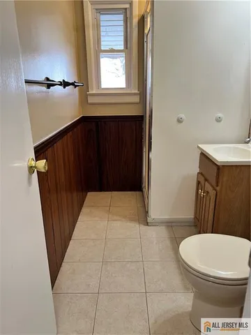 a bathroom with a sink a toilet a window and vanity