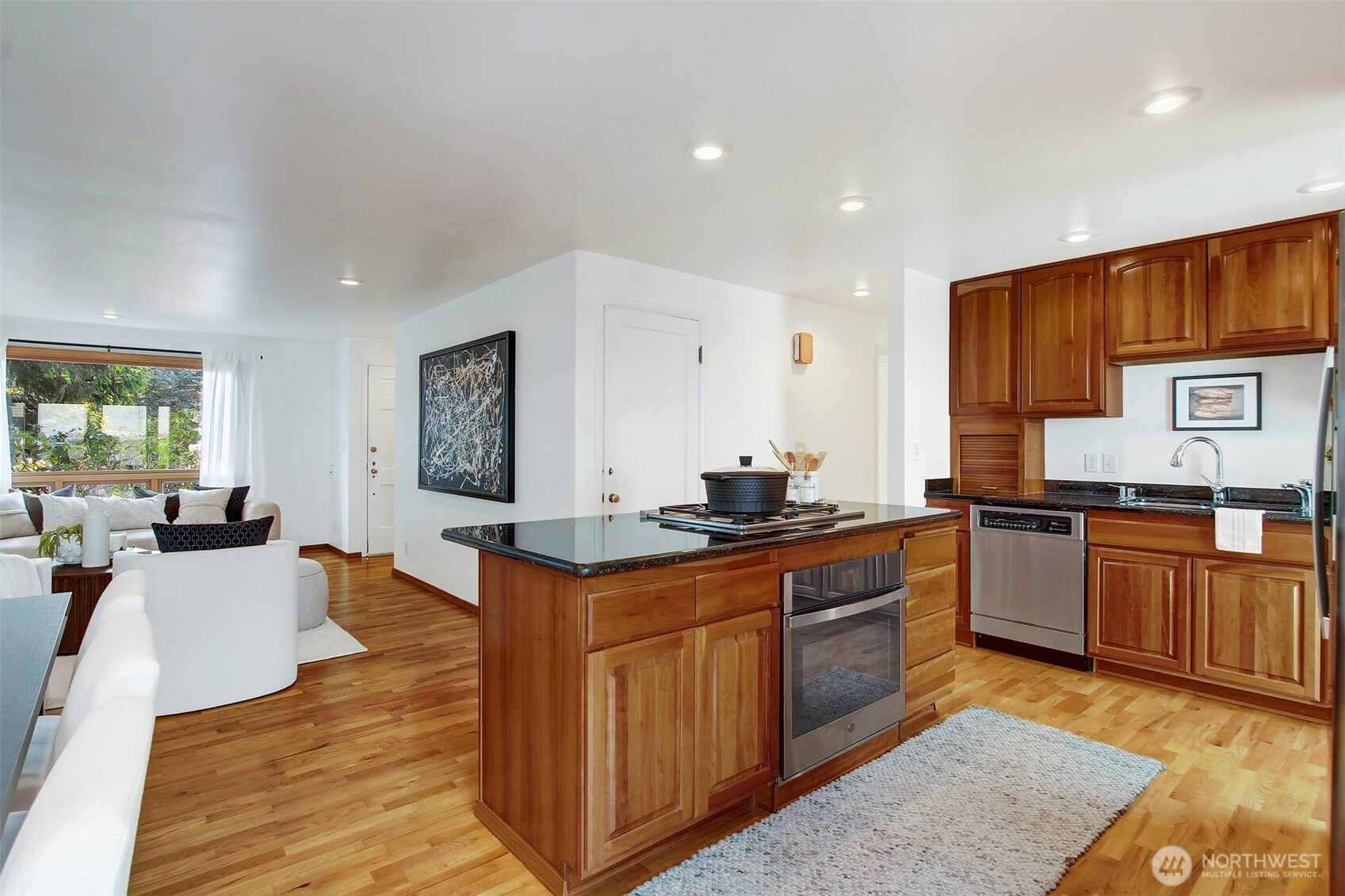 3236 32nd Avenue West Seattle, WA 98199 - Photo 8 of 33 a large kitchen with stainless steel appliances granite countertop a stove a sink dishwasher and a refrigerator with wooden floor