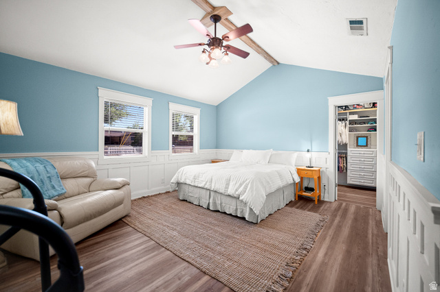 236 West 300 South Hurricane, UT 84737 - Photo 37 of 76 Vaulted ceiling bedroom featuring wood-finish flooring, wainscoting, a ceiling fan, dual windows, and an organized walk-in closet with built-in shelving