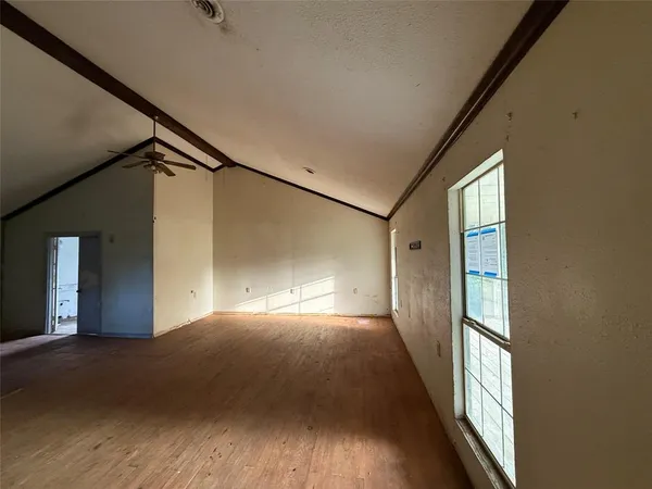a view of empty room with wooden floor