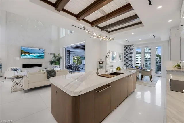 a large kitchen with sink a counter top space and living room view