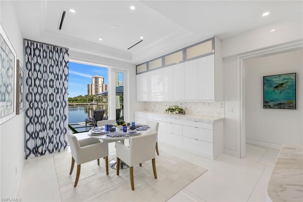 309 Neapolitan Way Naples, FL 34103 - Photo 13 of 33 a kitchen with a dining table chairs and window