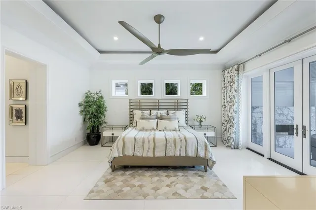 a bedroom with a large bed and a chandelier