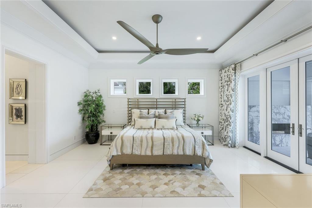 309 Neapolitan Way Naples, FL 34103 - Photo 16 of 33 a bedroom with a large bed and a chandelier