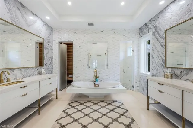a spacious bathroom with a double vanity sink mirror and bathtub