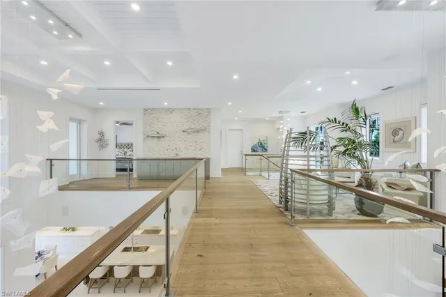 a large kitchen with kitchen island a large counter top and a view of living room
