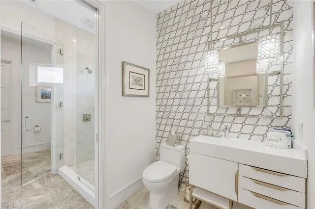 a bathroom with a sink a toilet and shower