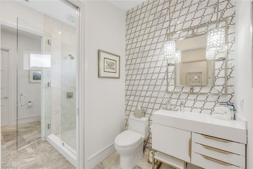 309 Neapolitan Way Naples, FL 34103 - Photo 26 of 33 a bathroom with a sink a toilet and shower