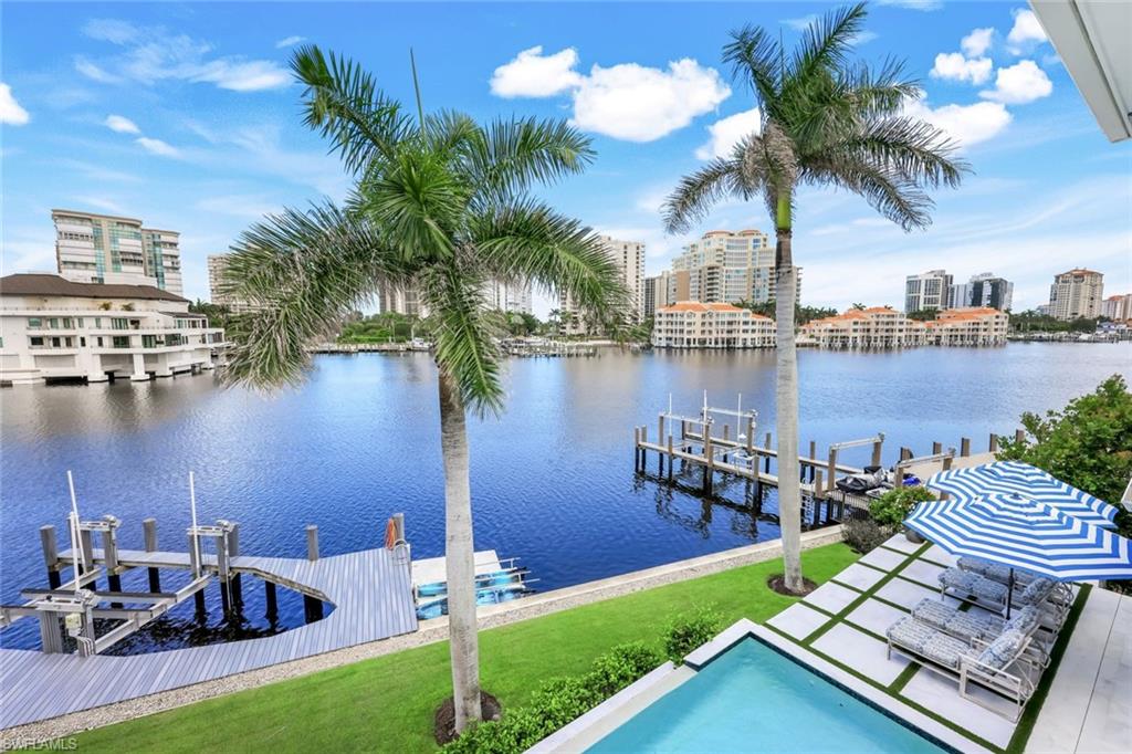 309 Neapolitan Way Naples, FL 34103 - Photo 32 of 33 a view of a lake with a table and chairs