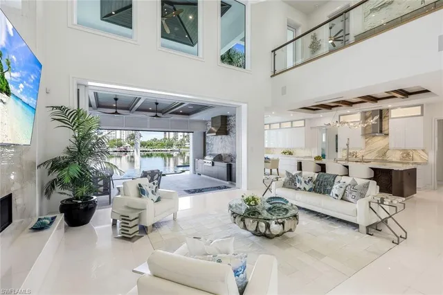 a living room with furniture and a large window with potted plants