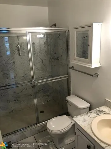 a white toilet sitting next to a bathroom sink