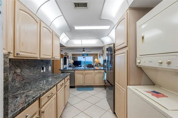a kitchen with stainless steel appliances granite countertop a sink and refrigerator
