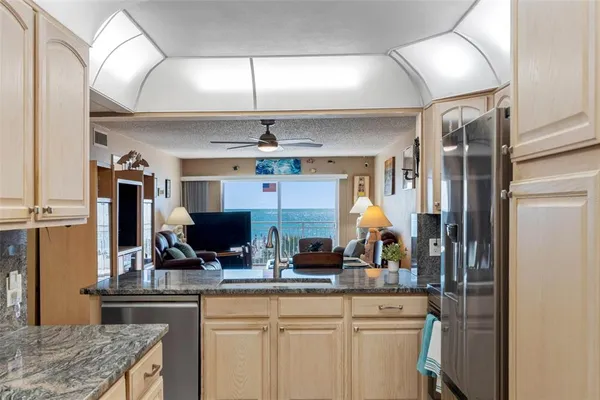a metallic refrigerator freezer sitting inside of a kitchen