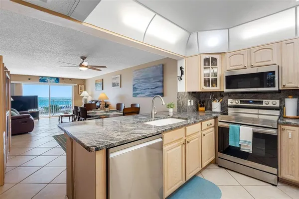 a kitchen with stainless steel appliances granite countertop a sink and a refrigerator