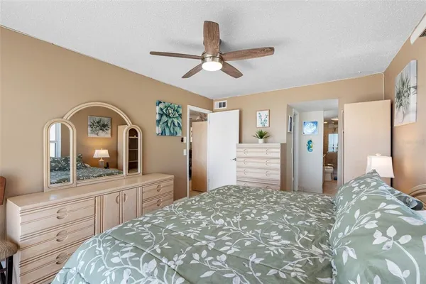 a bedroom with a bed a mirror on the dresser and a large mirror