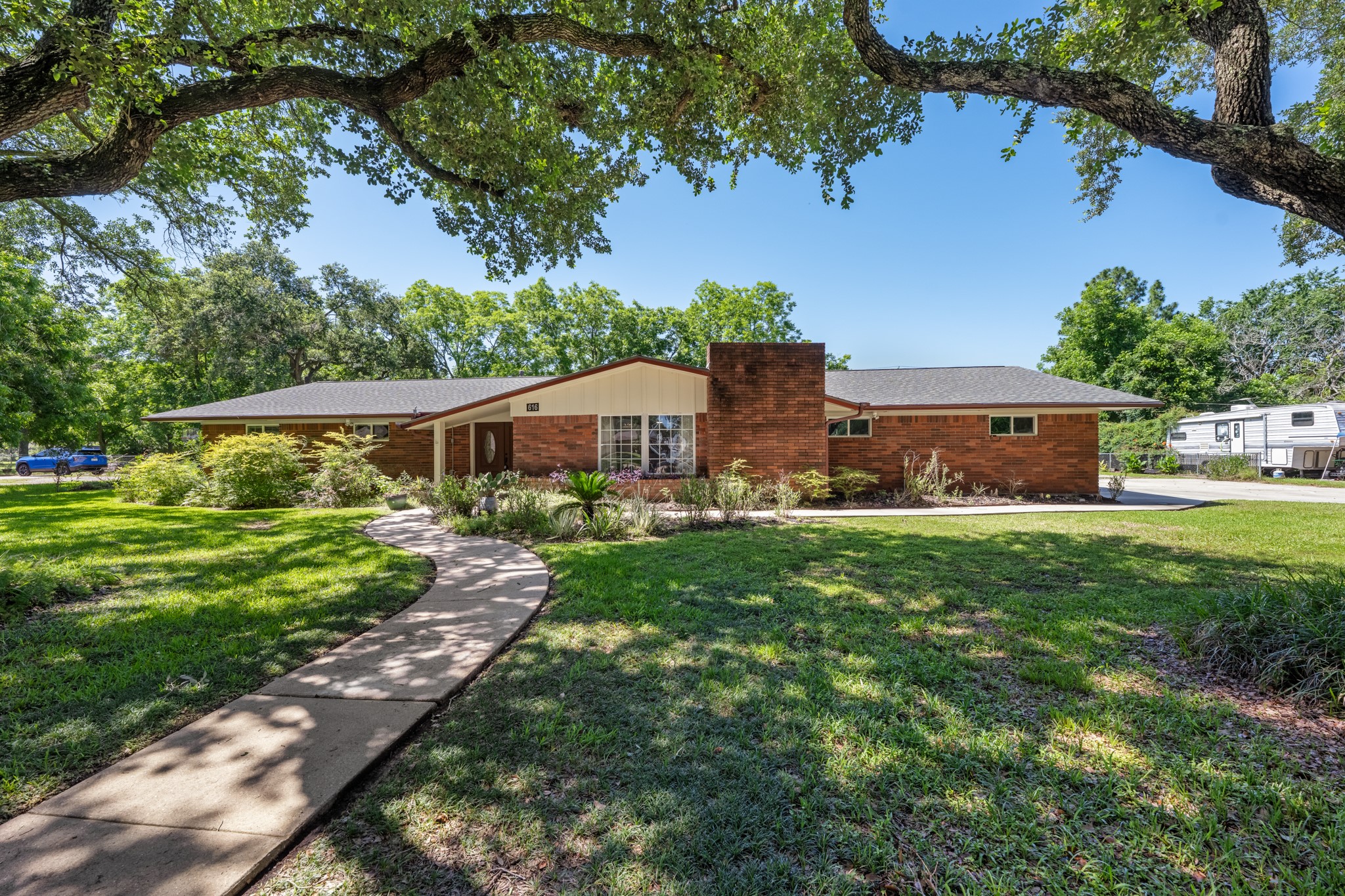 616 Cannan Drive Angleton, TX 77515 - Photo 1 of 49 A welcoming brick exterior is complemented by a curved walkway, mature shade trees, and expansive front lawn, creating strong curb appeal. The oversized lot and established landscaping provide a serene setting with plenty of outdoor space to enjoy.