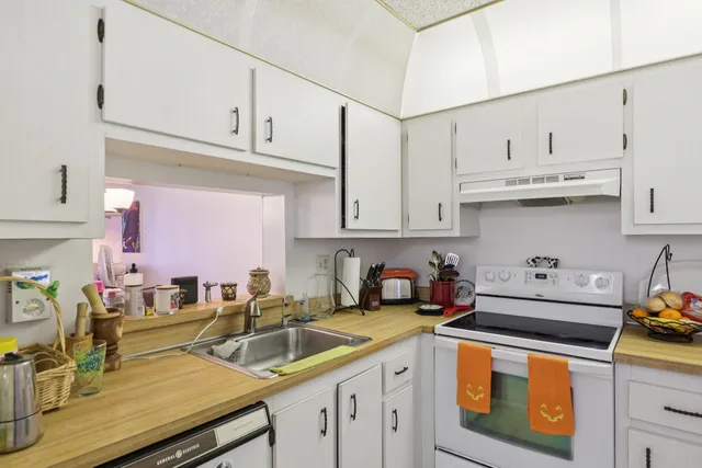 a kitchen with stainless steel appliances granite countertop a sink a stove and cabinets