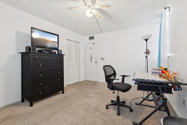 a view of a workspace with furniture and a flat screen tv