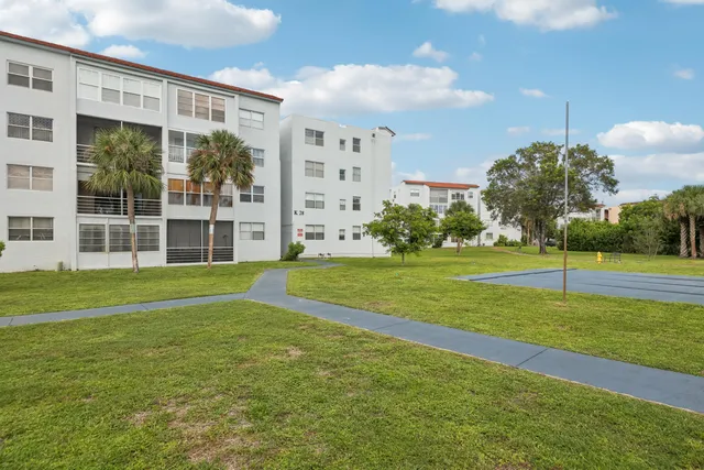 a view of a house with a big yard and potted plants