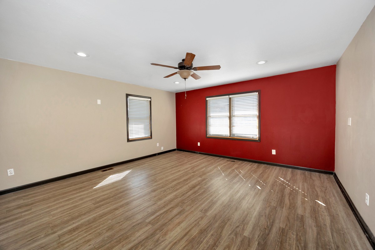 1969 Bobo Section Road Hazel Green, AL 35750 - Photo 21 of 47 a view of a livingroom with wooden floor a ceiling fan and windows