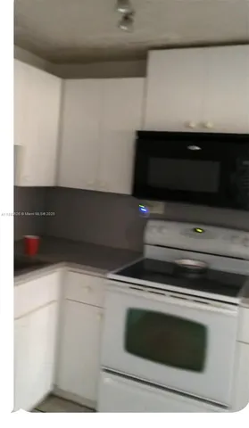 a kitchen with a sink window and cabinets