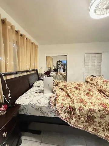 a bedroom with a bed and a flat tv screen on the dresser