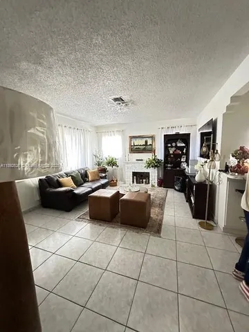 a living room with furniture and a open kitchen view