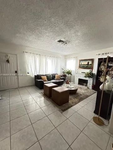 a large living room with stainless steel appliances kitchen island granite countertop a large window