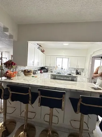 a kitchen with a sink and chairs