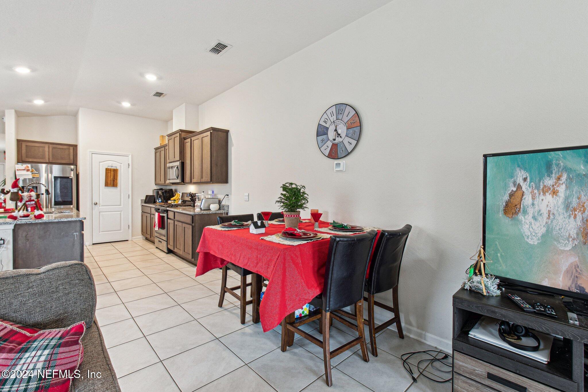 86253 Mainline Road Yulee, FL 32097 - Photo 12 of 39 a dining room with furniture and a flat screen tv